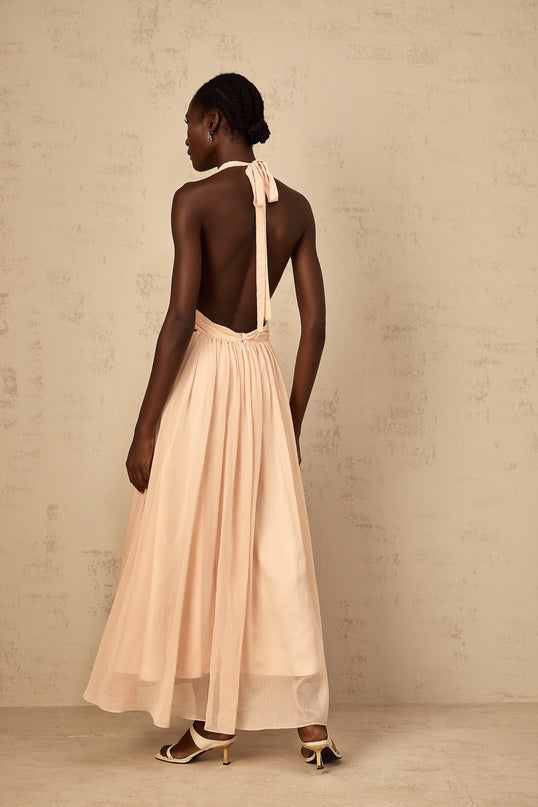 Teresa Maxi Dress in Peach Pink and Neutrals halter-neck silhouette shirred tulle fabric open back design maxi length cinched waist 100% Terylene fiber intricate detailing rear tie zip fastening special occasions
