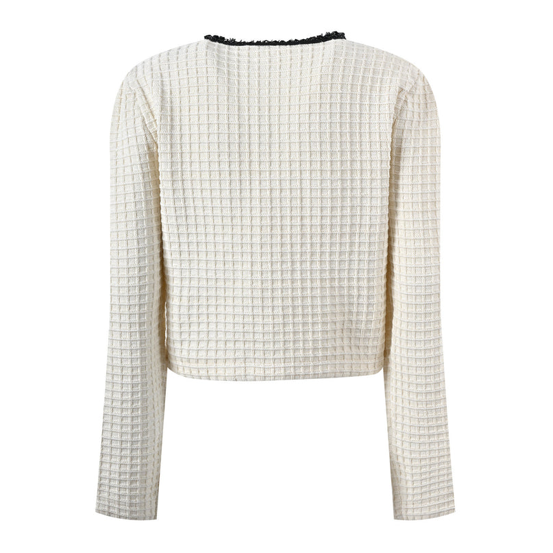 Textured white knitted jacket with black trim and decorative buttons paired with a ruffled hem skirt