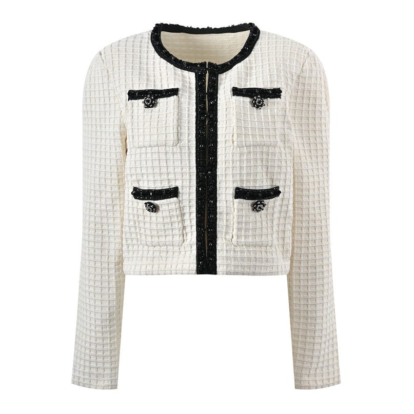Textured white knitted jacket with black trim and decorative buttons paired with a ruffled hem skirt
