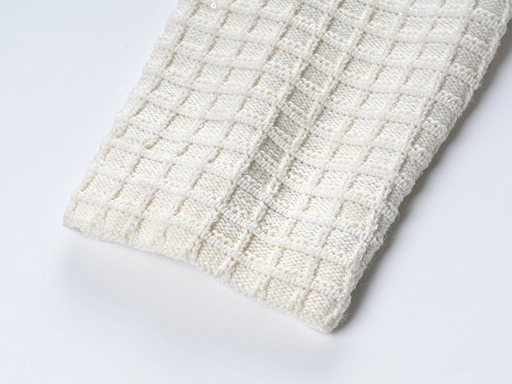 Textured white knitted jacket with black trim and decorative buttons paired with a ruffled hem skirt