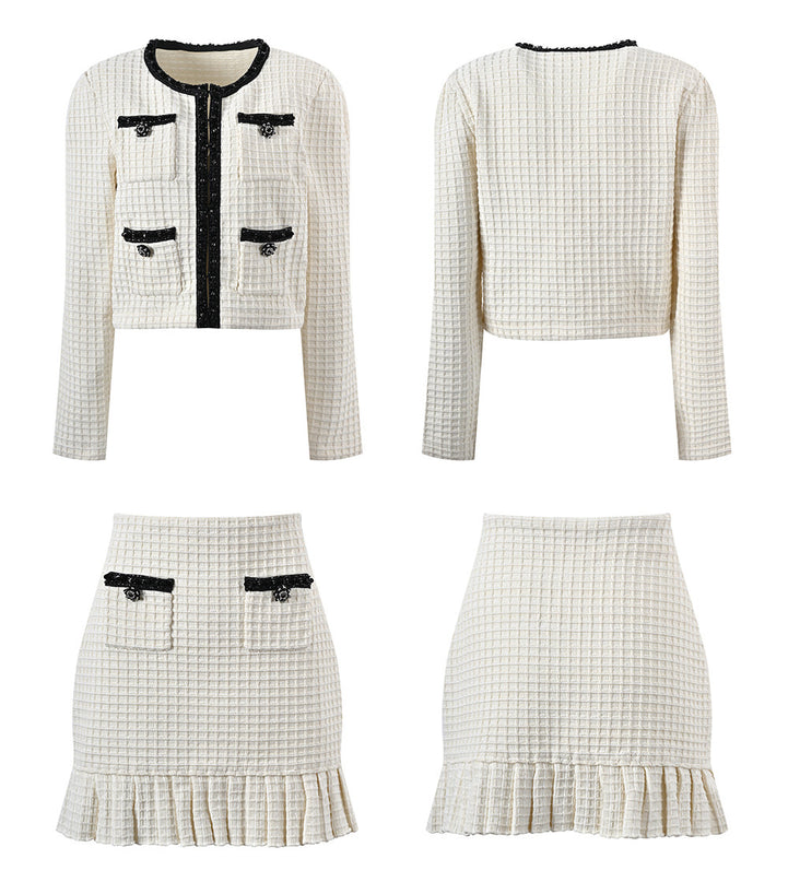 Textured white knitted jacket with black trim and decorative buttons paired with a ruffled hem skirt