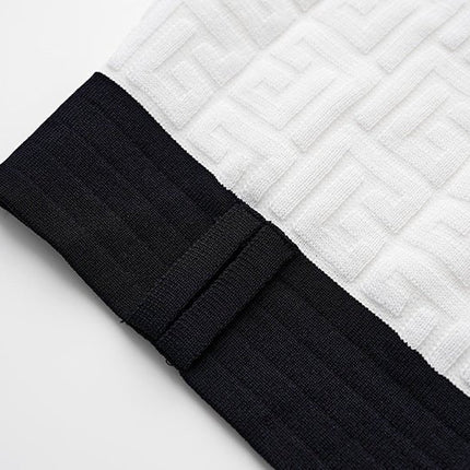 White and black military-inspired cropped jacket with gold-tone buttons and textured fabric