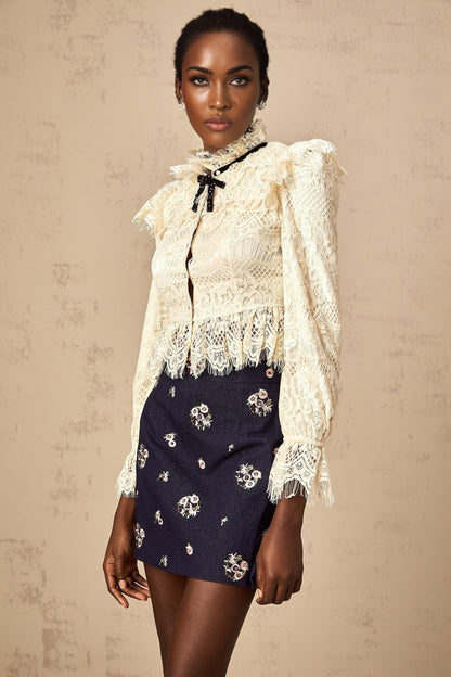 White blouse with floral lace pattern and bow detail at neckline