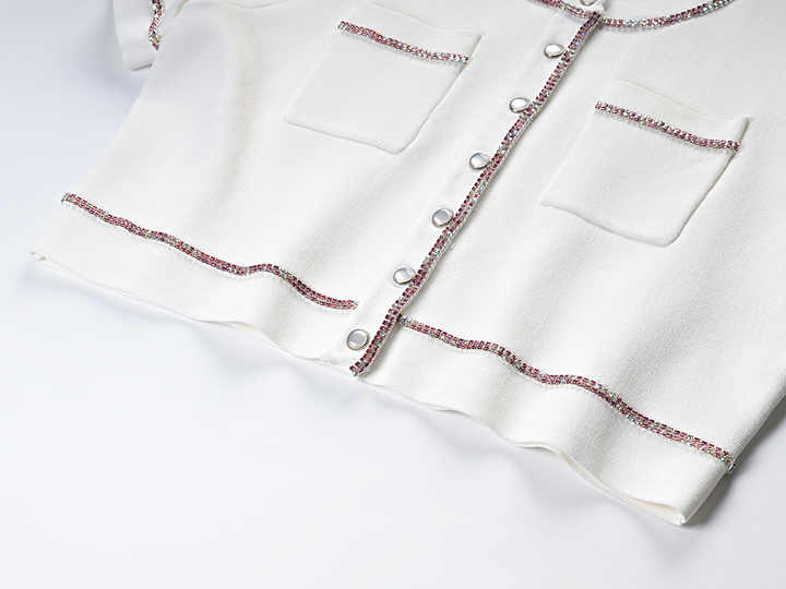 White cropped top and high-waisted skirt with button-up design and pocket details