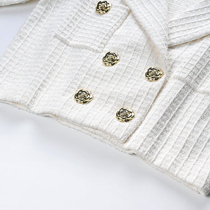 White double-breasted blazer with gold accents and fitted skirt