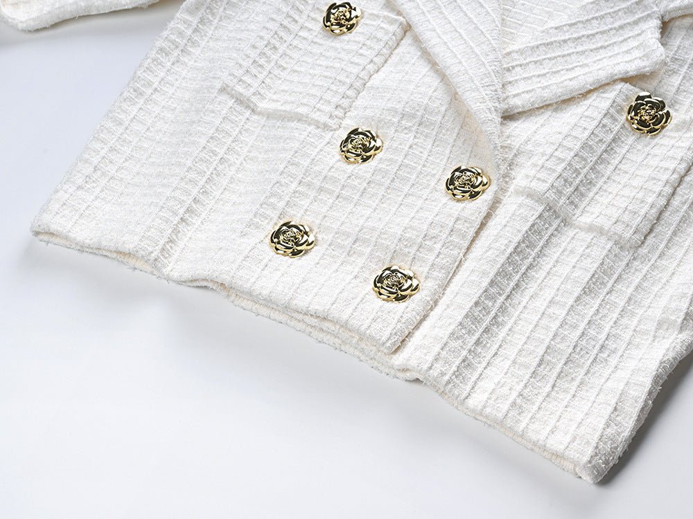 White double-breasted blazer with gold accents and fitted skirt
