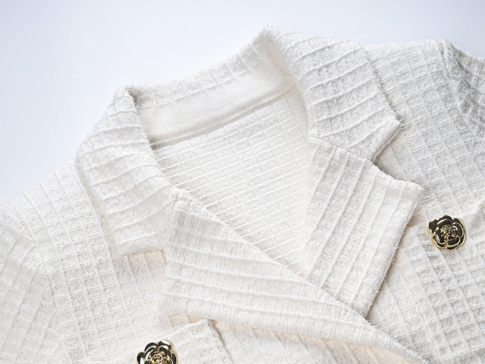 White double-breasted blazer and skirt set with gold accents