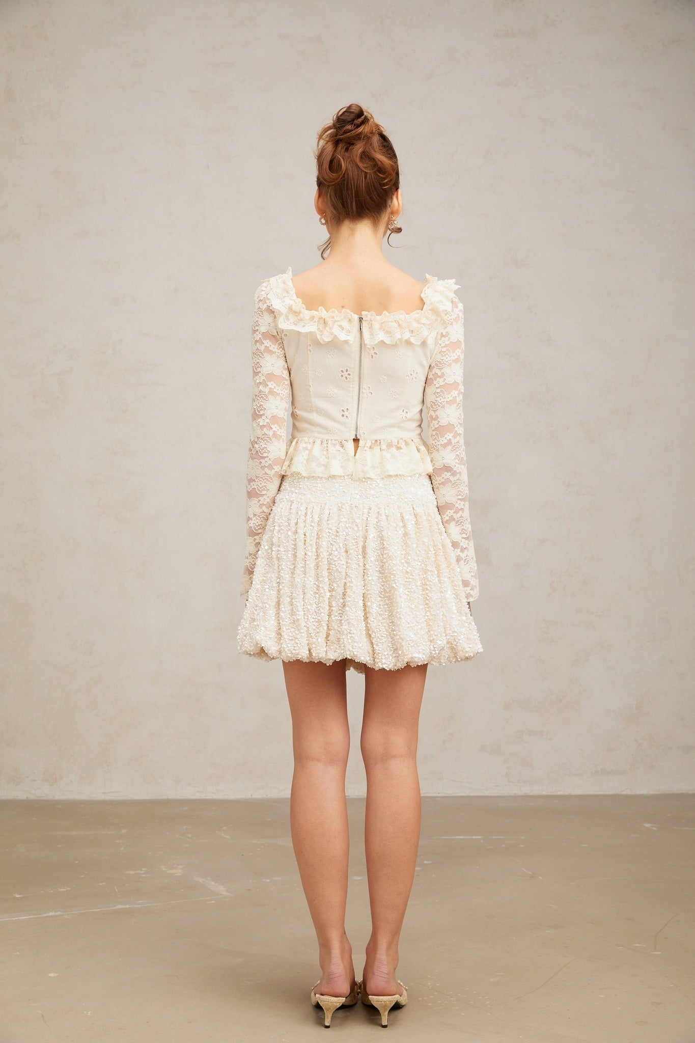 White lace blouse with floral pattern and ruffled details