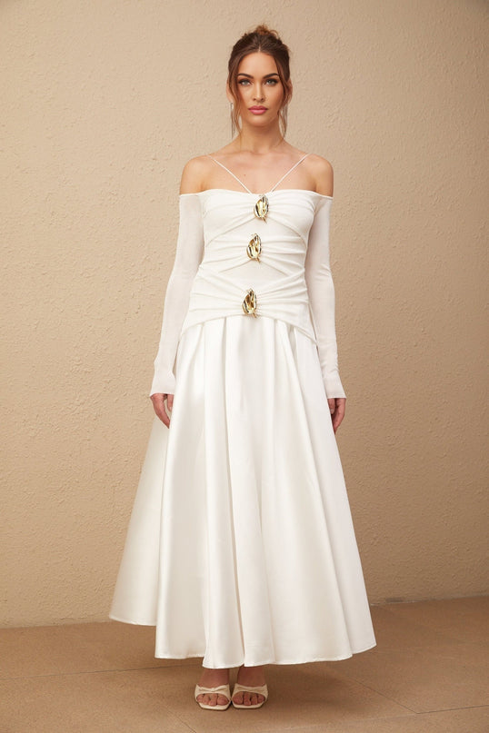 White offshoulder maxi dress with panels worn by model standing against plain background