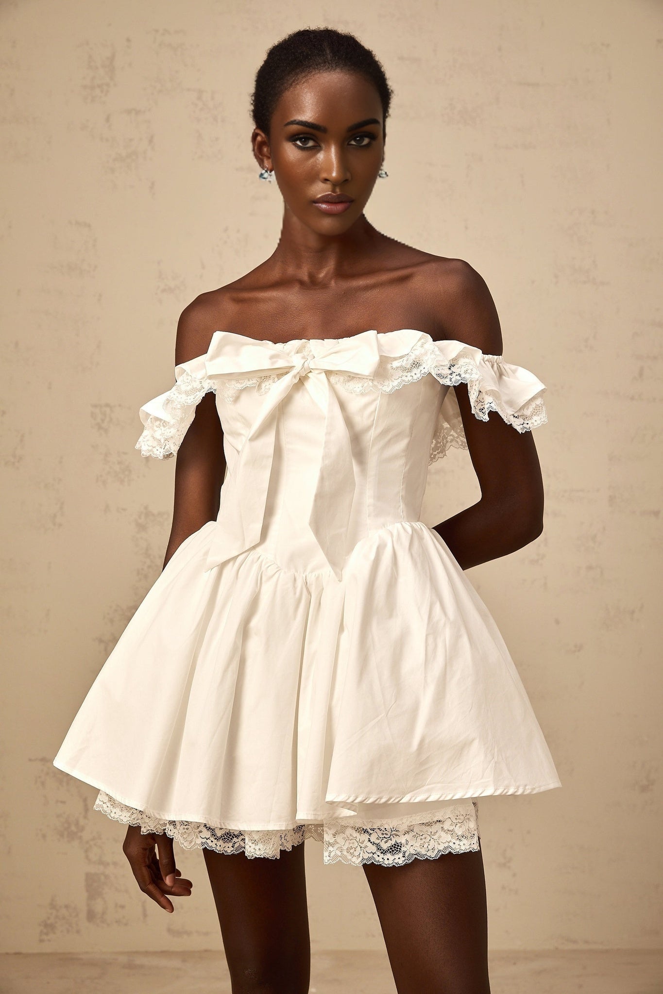 White oversized mini dress with ruffles and large bow detail