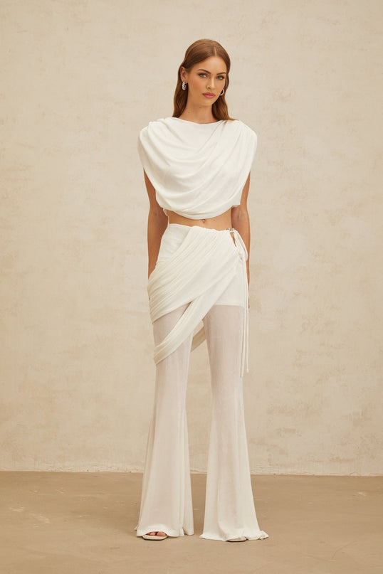 White sleeveless bateau neck cropped top and high rise flared trousers with ruched detailing and draped design in Terylene fiber composition