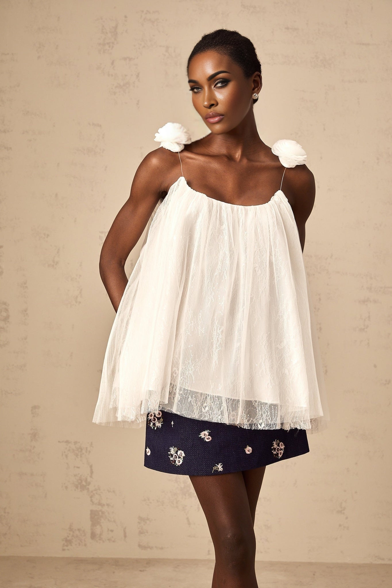 White sleeveless top with floral applique details on sheer mesh fabric