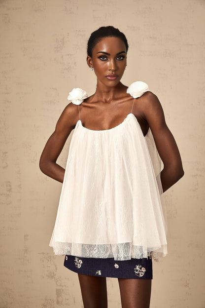White sleeveless top with sheer mesh fabric and floral appliques