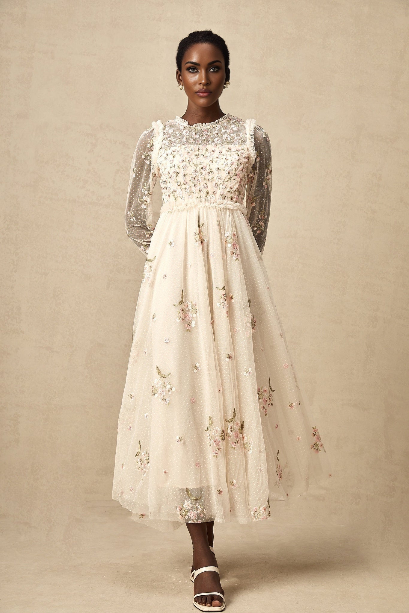 White tulle midi dress with colorful floral embroidery by Celine featuring sheer sleeves and delicate floral patterns throughout the bodice and skirt