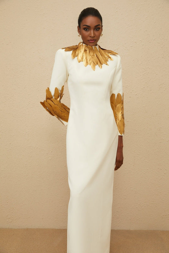 White turtleneck maxi dress with gold feather trim and rear slit