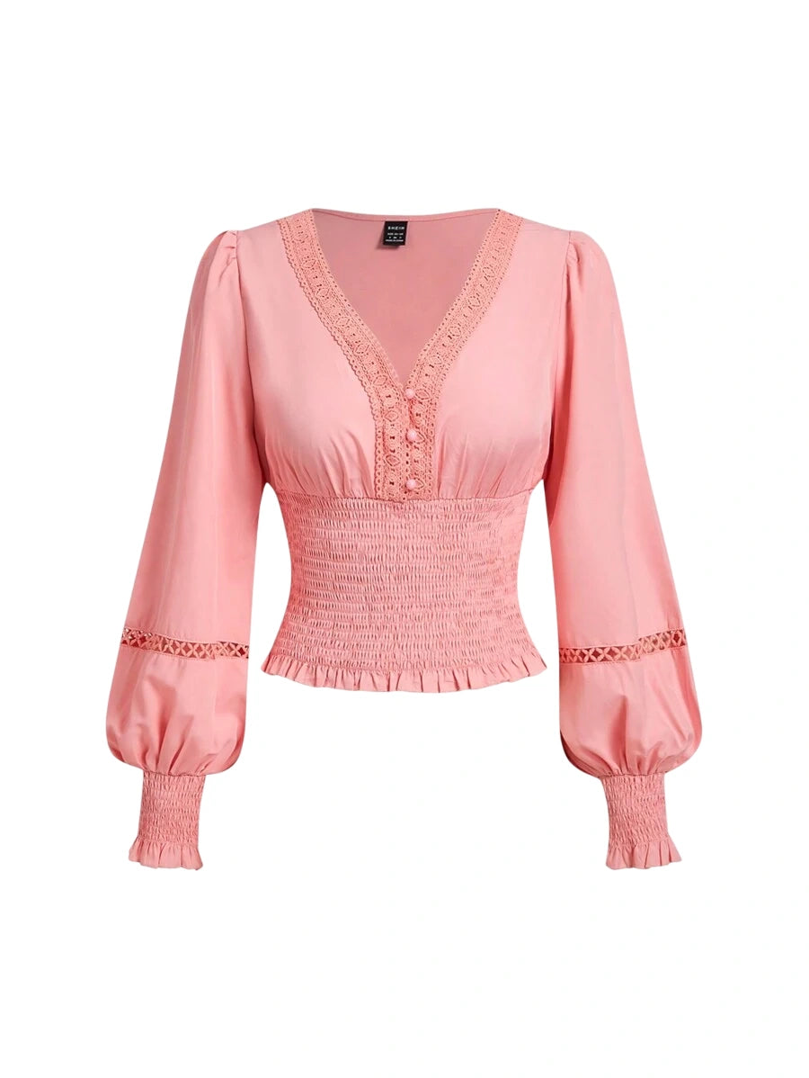 Pink smocked blouse with lace details and puffed sleeves