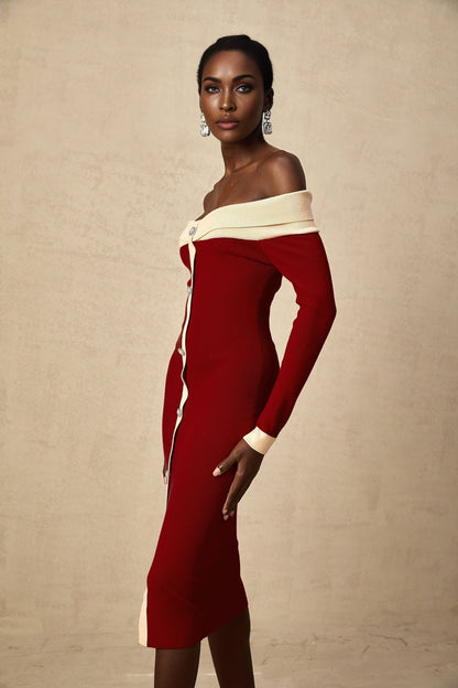 Woman wearing a beige offshoulder knit midi dress with long sleeves standing against a plain background