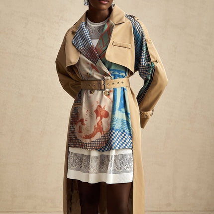 Woman wearing a belted trench coat with contrasting color panels and printed design