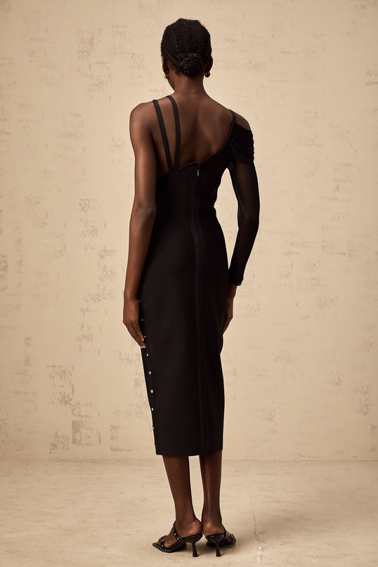 Woman wearing a black asymmetric midi dress with cutout details