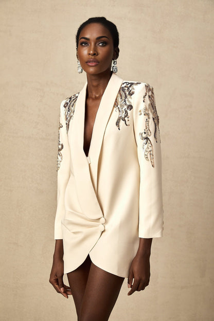 Woman wearing a black blazer dress covered in shimmering sequins with embellished details