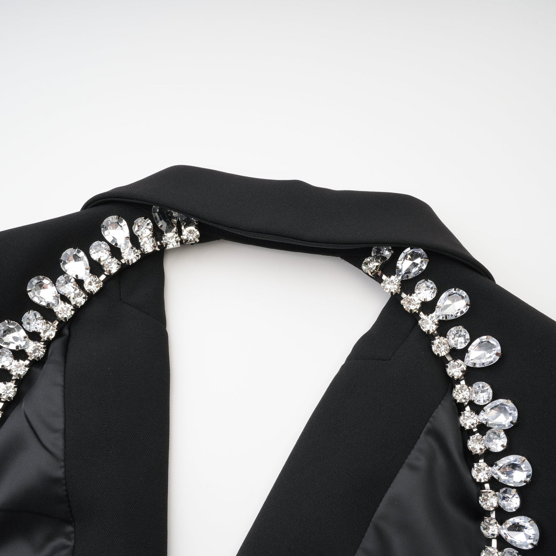 Elegant black dress with long sleeves notched lapels scoop back buttoned cuffs fitted waistline and crystal embellishment % Polyester