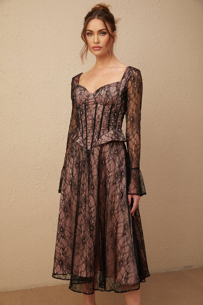Woman wearing a black lace midi dress with flared skirt and fitted bodice standing against plain background