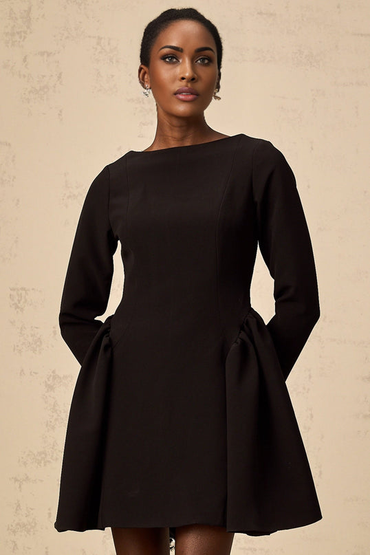 Woman wearing a black long sleeve mini dress with a flared skirt