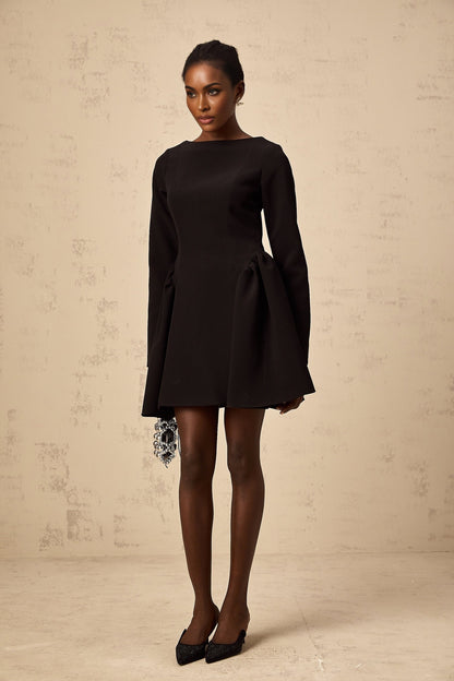 Woman wearing a black longsleeve mini dress with a flared skirt