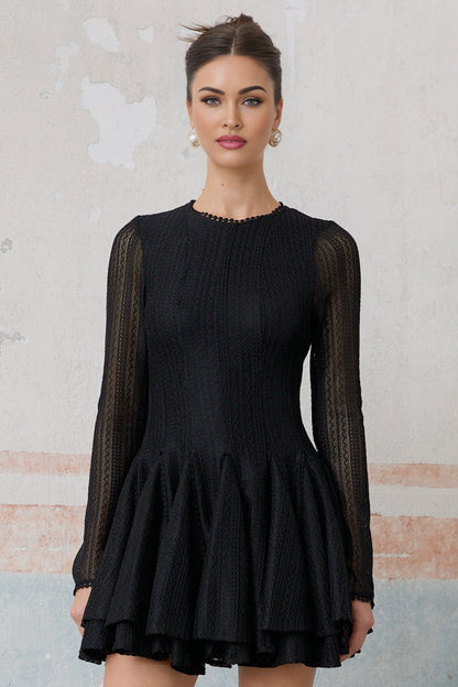 Woman wearing a black mini dress with puff sleeves and pointelle pattern detail
