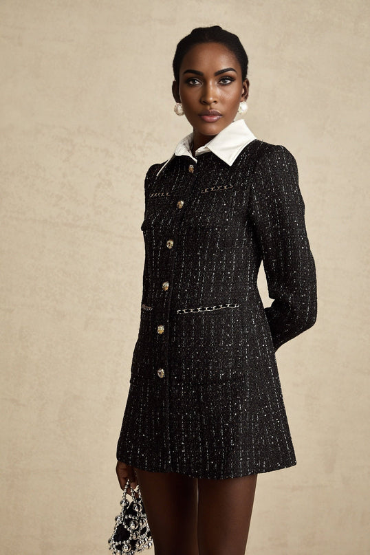 Woman wearing a black mini dress with sequin panels and tweed fabric Audrey style short sleeves fitted silhouette