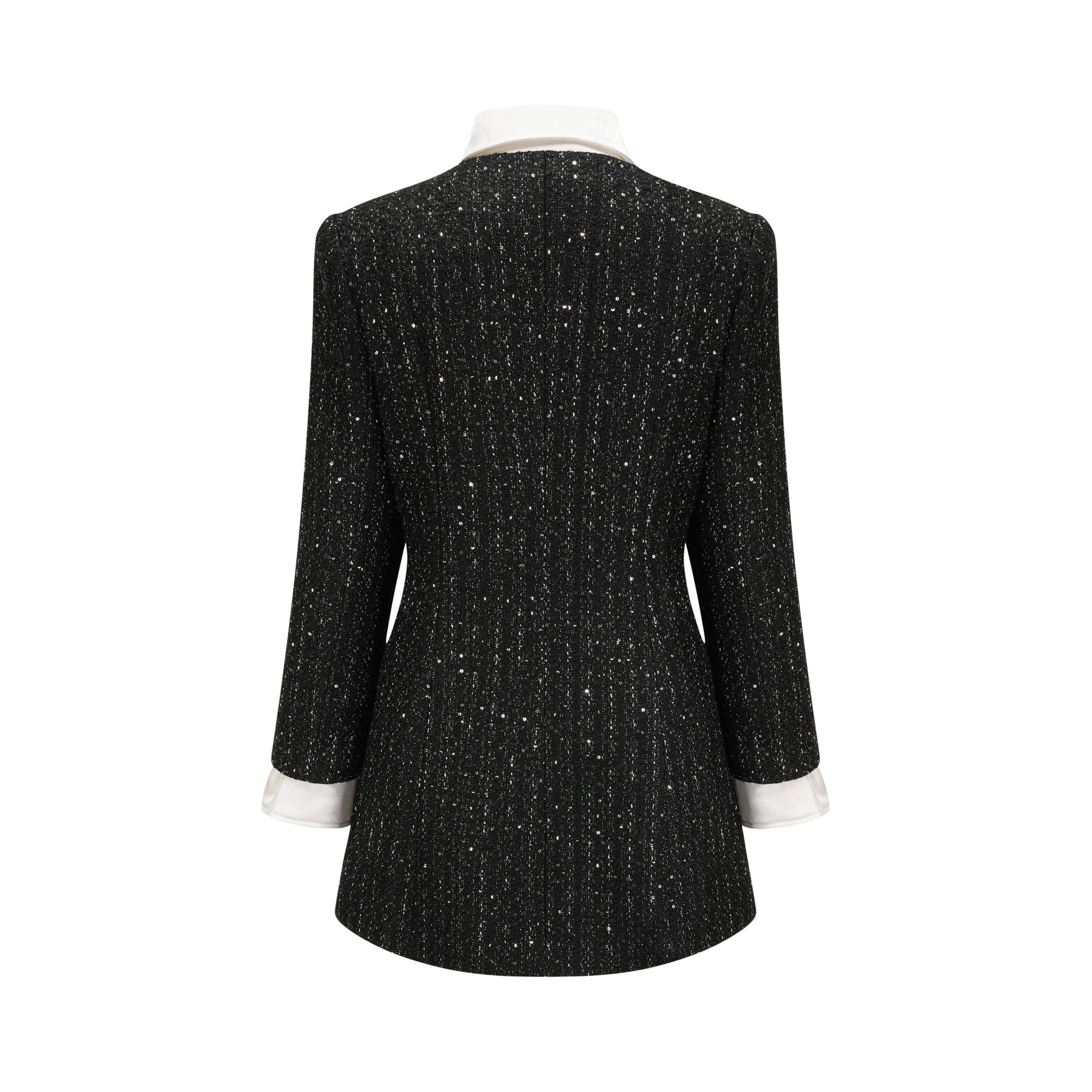 Woman wearing a black mini dress with tweed fabric and sequin panels Audrey style dress with short length and mixed textures