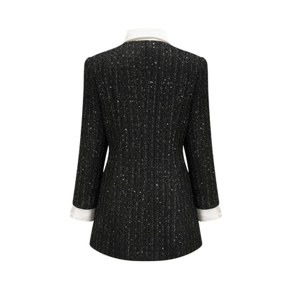 Woman wearing a black mini dress with tweed fabric and sequin panels Audrey style dress with short length and mixed textures