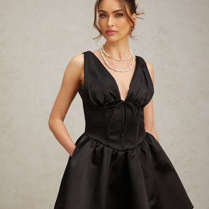 Woman wearing a black mini dress with Vneck and flared skirt