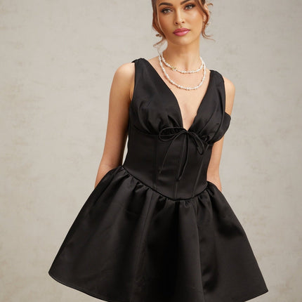 Woman wearing a black mini dress with Vneck and flared skirt