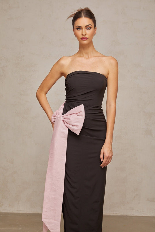 Woman wearing a black off shoulder maxi dress with a bow detail