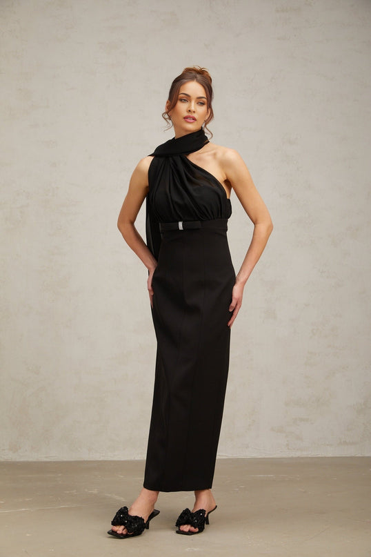 Woman wearing a black oneshoulder midi dress with draped fabric detail