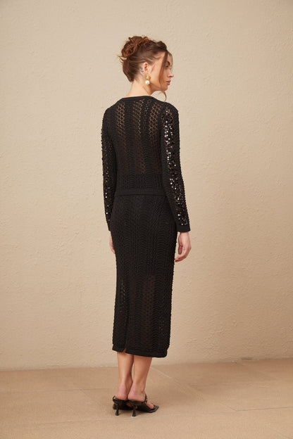 Woman wearing a black sequined matching set consisting of a crochet knit cardigan and skirt named Ophelie