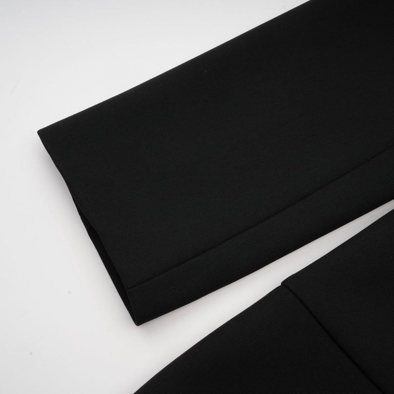 Woman wearing a black singlebreasted blazer dress with a fitted silhouette and lapel collar