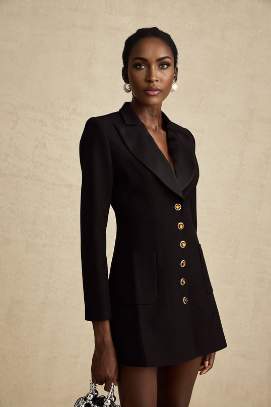 Woman wearing a black singlebreasted blazer dress with a tailored fit and sleek design