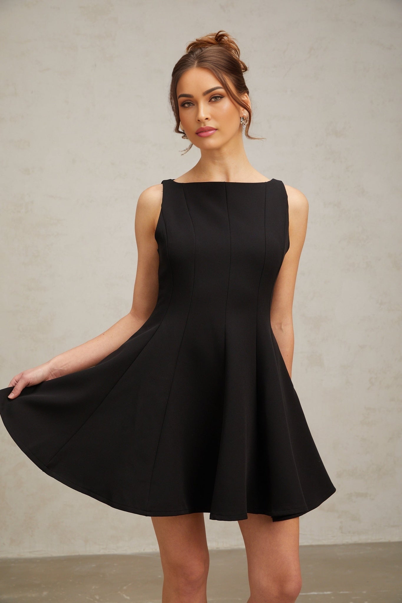 Woman wearing a black sleeveless mini dress with a flared skirt