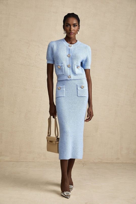 Woman wearing a blue knit matching set consisting of a blouse and skirt