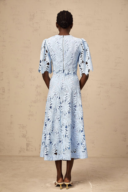 Woman wearing a blue lace top and matching skirt set in Audrey style with guipure lace detailing