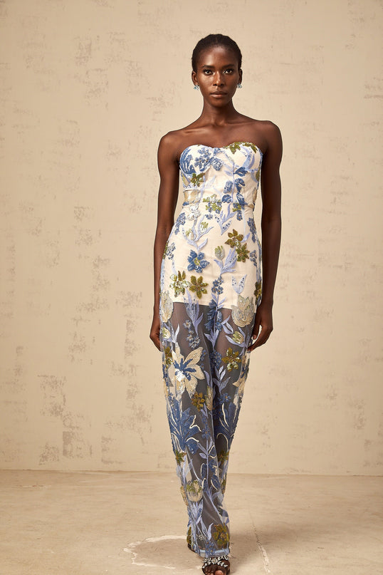 Woman wearing a blue maxi dress with sequined flower embroidery and a corset bodice featuring a full tulle skirt