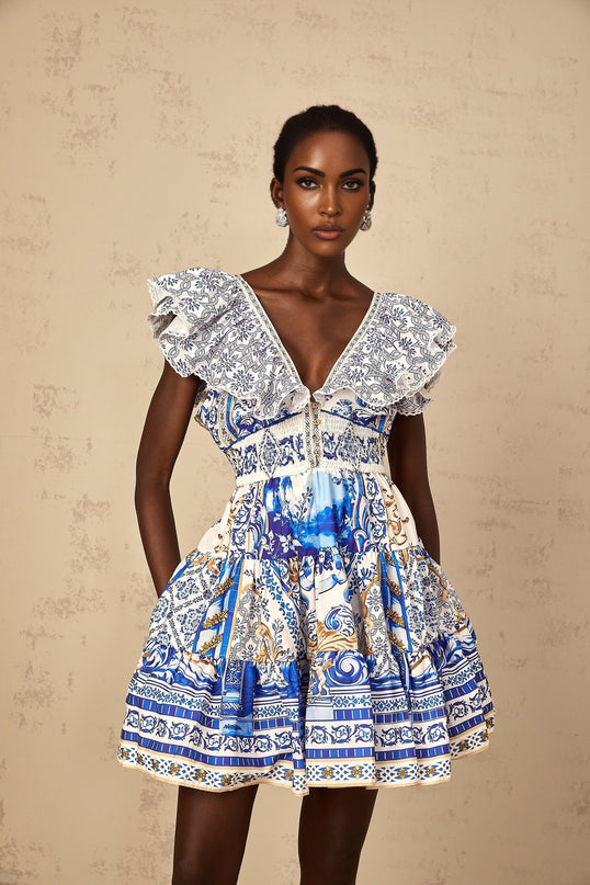 Woman wearing a blue mini dress with baroque print pattern and tiered skirt design