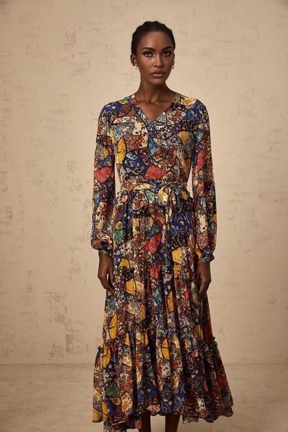 Woman wearing a brown bohemian style midi dress with shirring details and flowy sleeves in outdoor setting