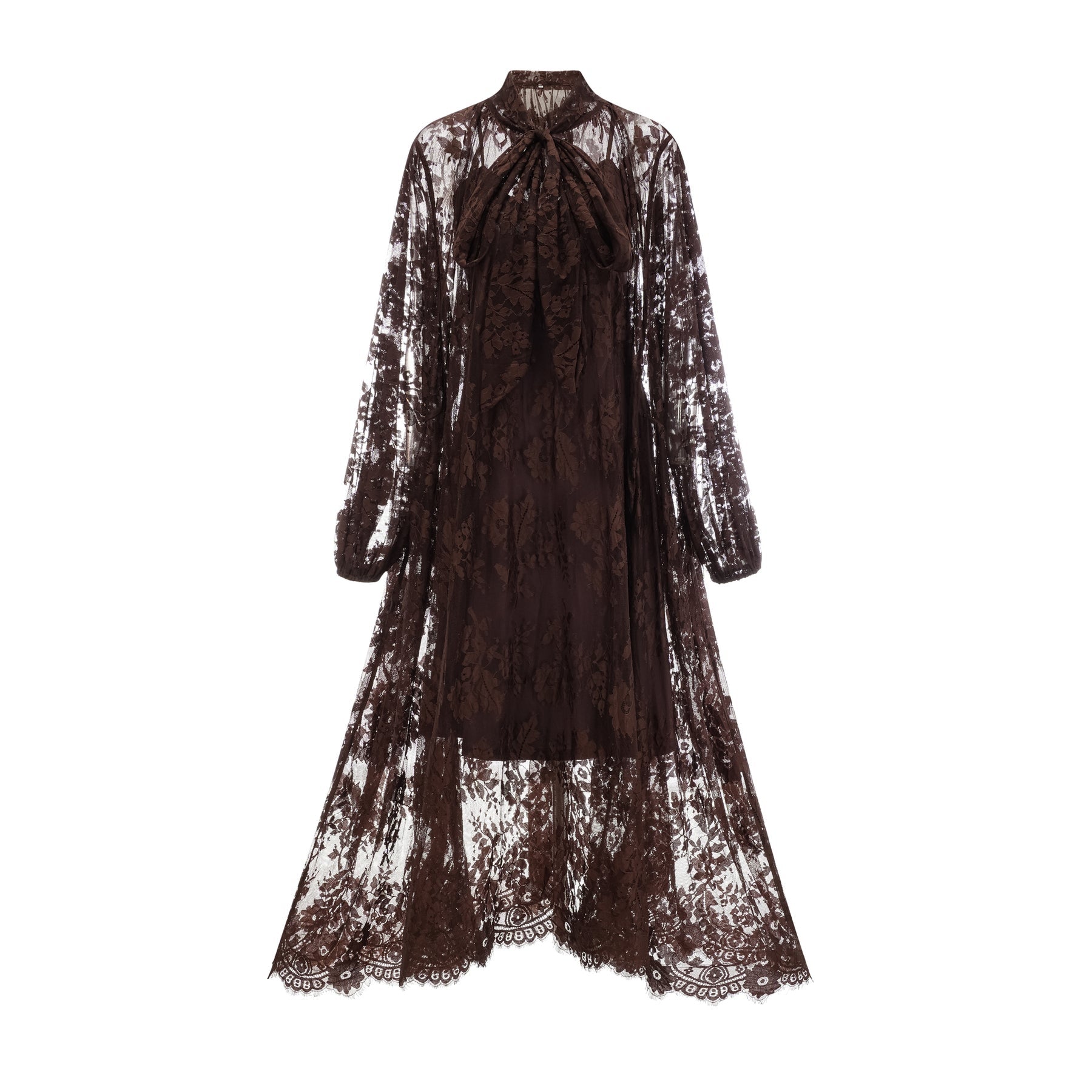 Woman wearing a brown flared midi dress made of chantilly lace with a fitted bodice and flowy skirt standing in a neutral background