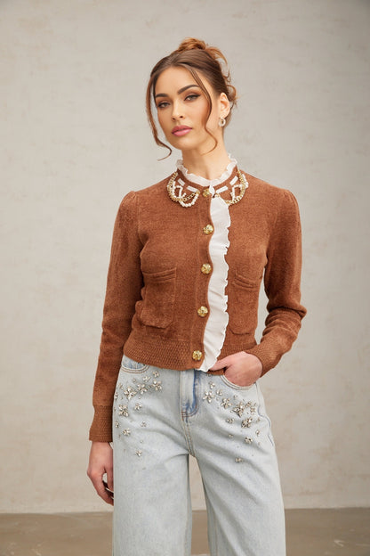 Woman wearing a brown knit cardigan with ruffled details and embellishments
