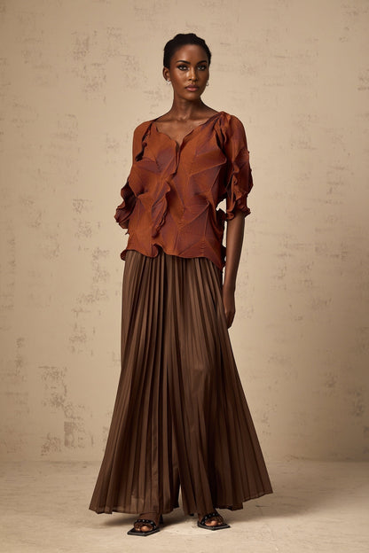 Woman wearing a brown matching set consisting of a creased top and skirt in demi style