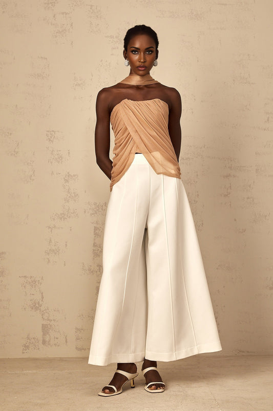 Woman wearing a brown sleeveless top with sequin embellishments and ruched tulle fabric