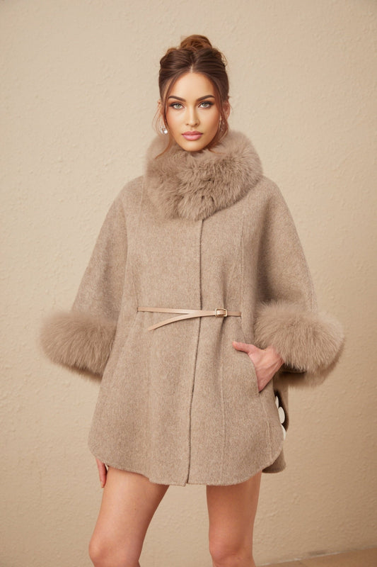 Woman wearing a brown wool cape coat with fur trim and belt cinched at waist